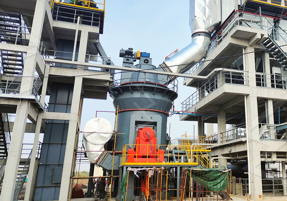 Engineers overseeing the installation of a large vertical grinding mill in an industrial plant